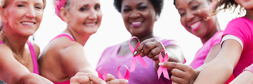Multiple women, dressed in pink, celebrating breast cancer awareness month