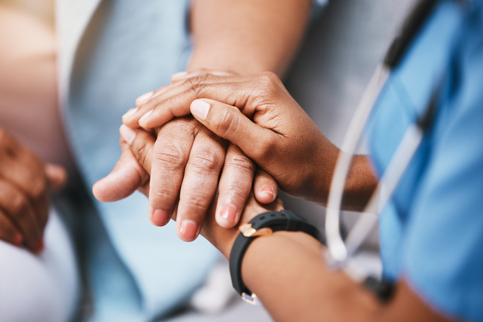 home health nurse holding hands with patient for help