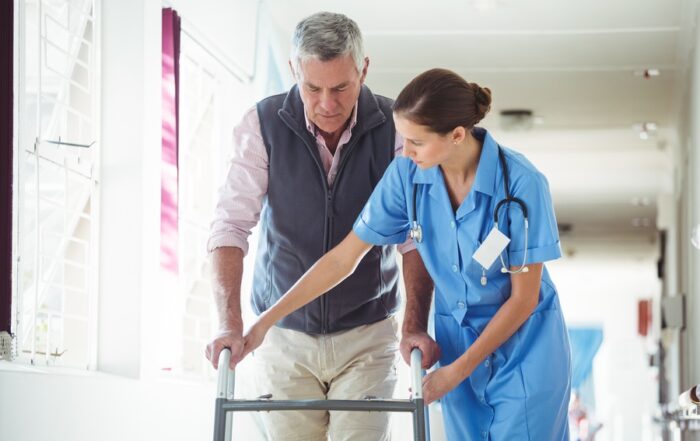 Nurse helping senior man with walking aid