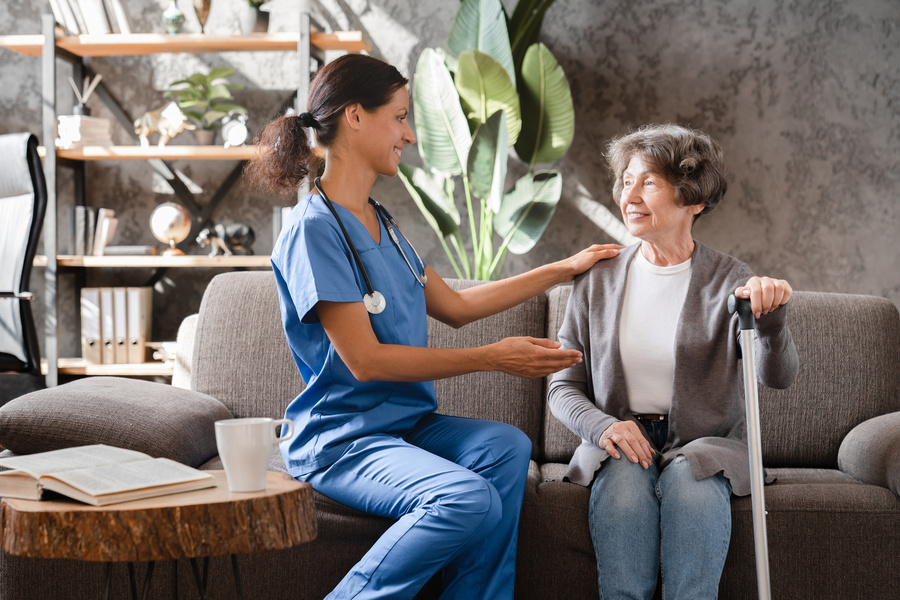 Middle-aged caregiver nurse taking care of elderly senior patient
